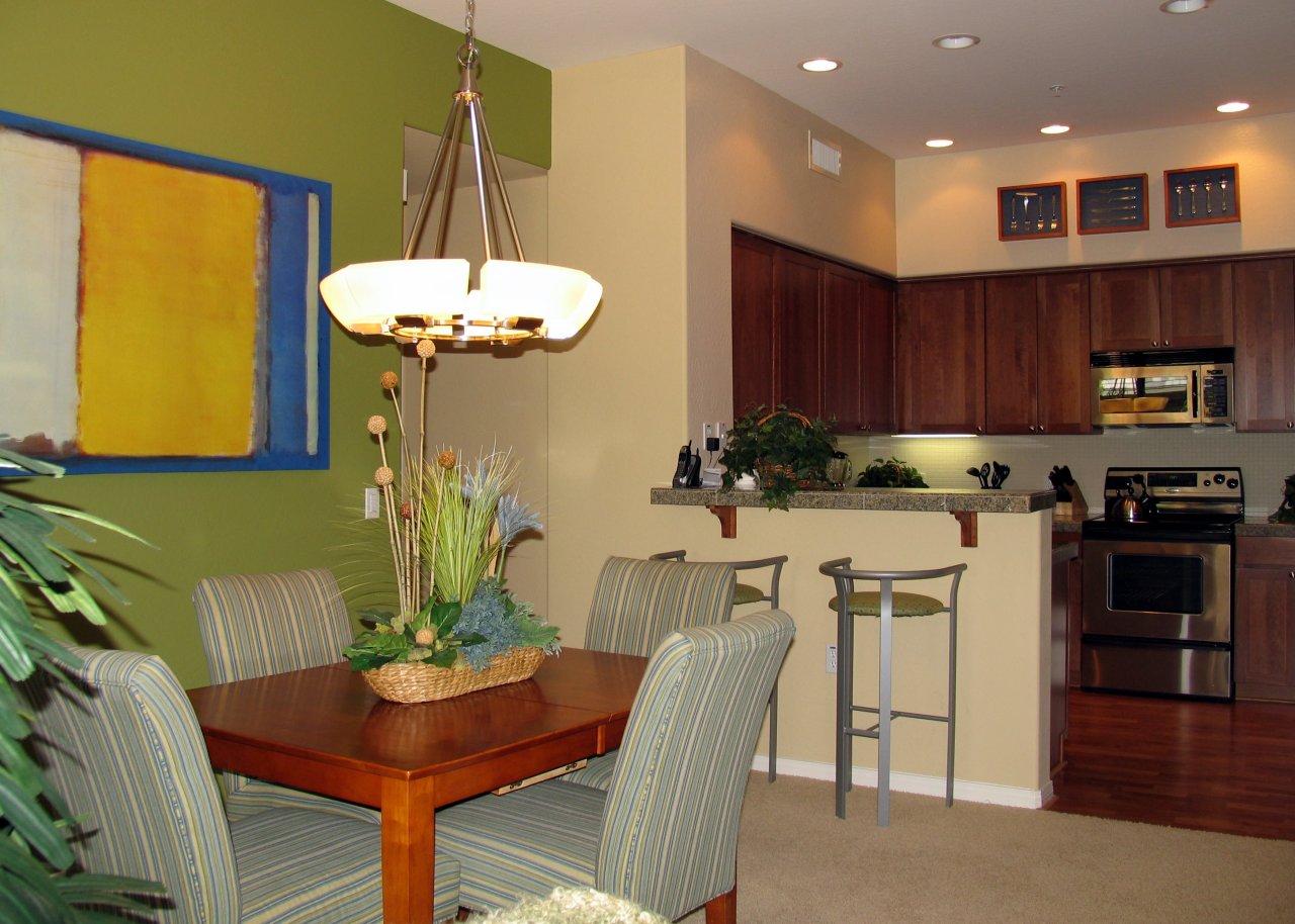 4488 East Thomas Road, Unit 2009 Phoenix, AZ 85018 - Photo 4 of 11 a kitchen with stainless steel appliances granite countertop a dining table chairs and a refrigerator