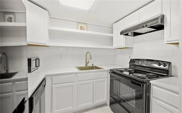 a kitchen with white cabinets stainless steel appliances and sink