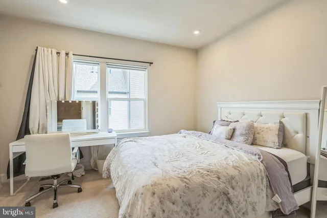 a large white bed sitting in a room next to a window