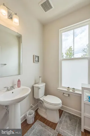 a bathroom with a toilet a sink and a window
