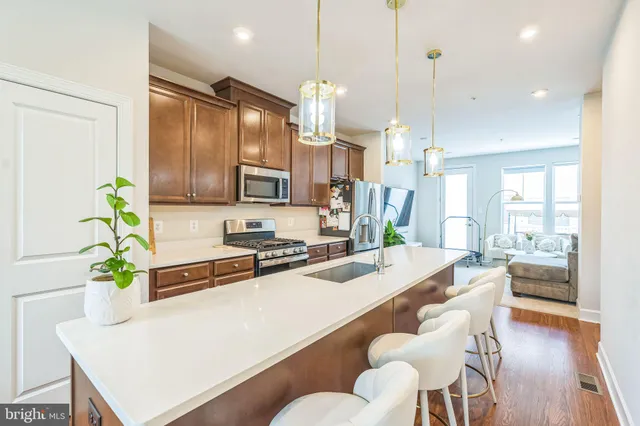 a kitchen with stainless steel appliances a dining table chairs stove refrigerator and kitchen view