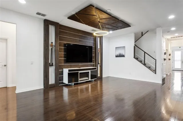 a view of an empty room with wooden floor windows and a fireplace