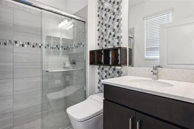 a bathroom with a sink toilet and shower