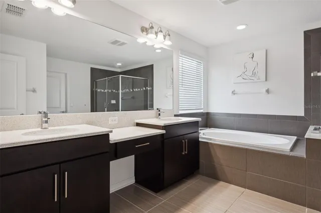 a bathroom with a sink double vanity granite tub and a mirror