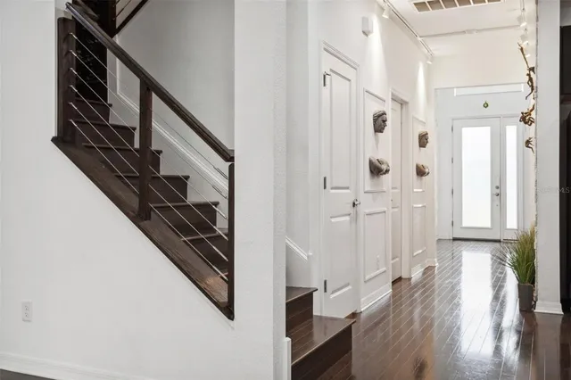 a view of a hallway with wooden floor and staircase