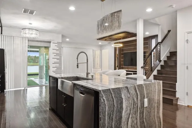 a kitchen with stainless steel appliances granite countertop a sink and a refrigerator