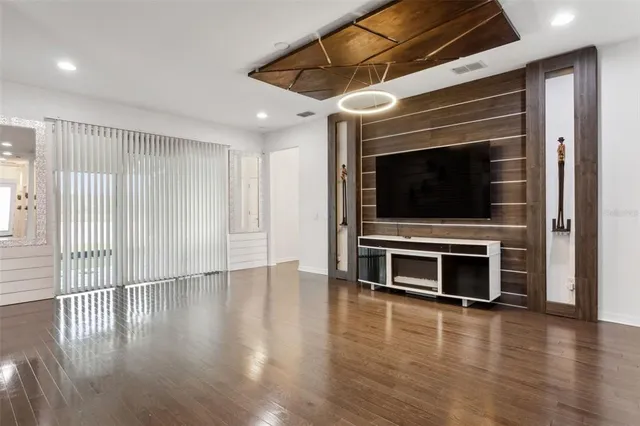 a view of a livingroom with wooden floor flat screen tv and windows