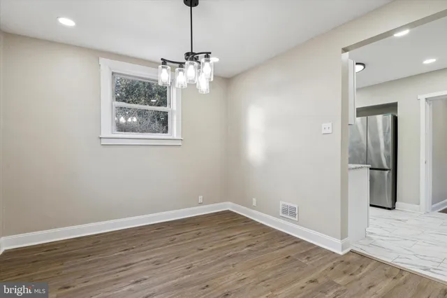 a view of empty room with wooden floor and window