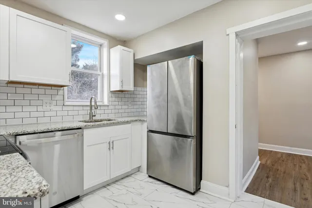 a kitchen with stainless steel appliances granite countertop a refrigerator and a sink