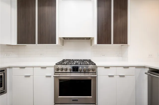 a stove top oven sitting inside of a kitchen