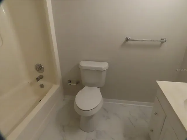 a white toilet sitting next to a bath tub