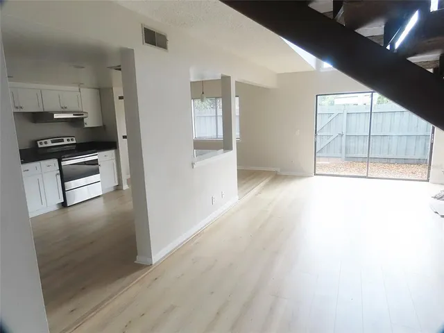 a view of a kitchen with wooden floor and electronic appliances