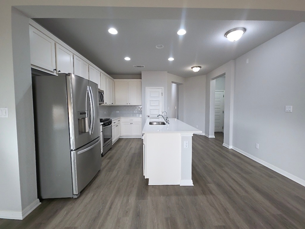 533 Rearing Mare Pass Georgetown, TX 78626 - Photo 5 of 22 a kitchen with kitchen island a sink stainless steel appliances and cabinets