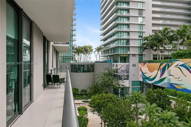 a view of a balcony with chairs and wooden fence