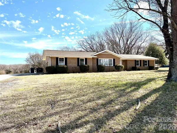 a front view of house with yard and trees around