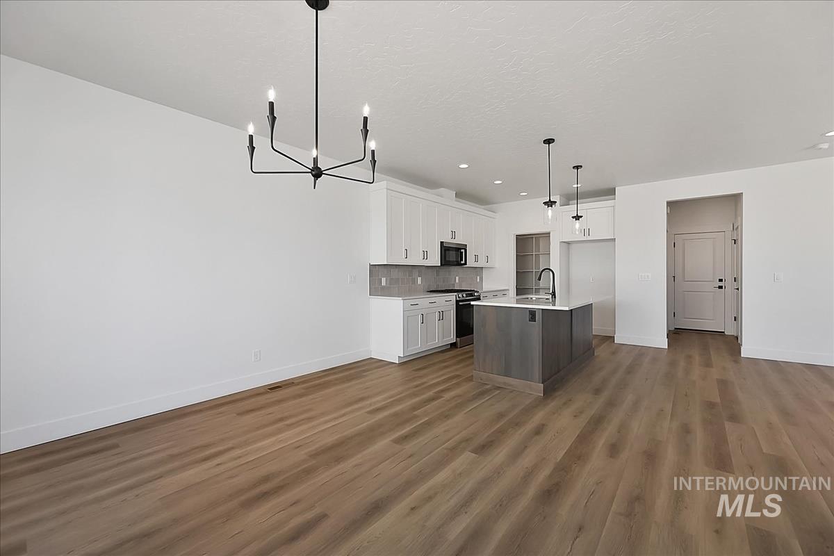 776 South Calhoun Lane Star, ID 83669 - Photo 13 of 49 Open-concept living area featuring wood-finish flooring and a contemporary black chandelier