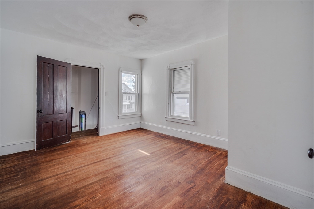 50 Home Street Springfield, MA 01104 - Photo 13 of 18 an empty room with wooden floor and windows