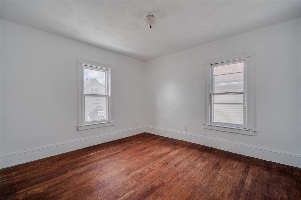 50 Home Street Springfield, MA 01104 - Photo 14 of 18 an empty room with wooden floor and windows