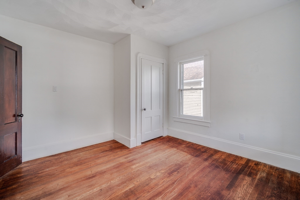 50 Home Street Springfield, MA 01104 - Photo 16 of 18 an empty room with wooden floor and windows