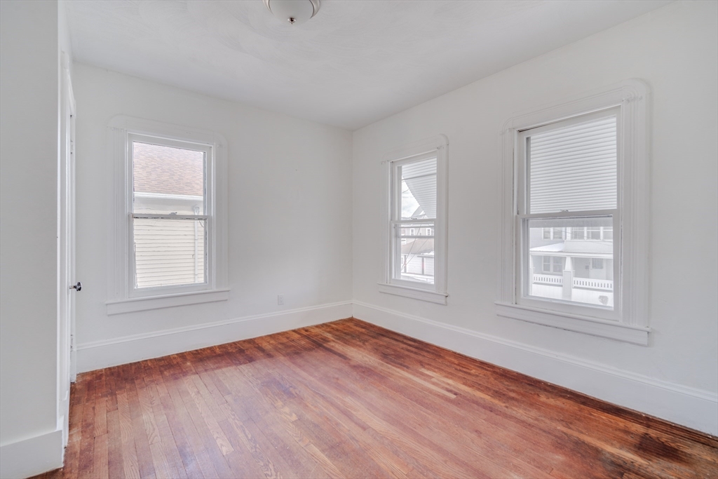 50 Home Street Springfield, MA 01104 - Photo 4 of 18 an empty room with wooden floor and windows