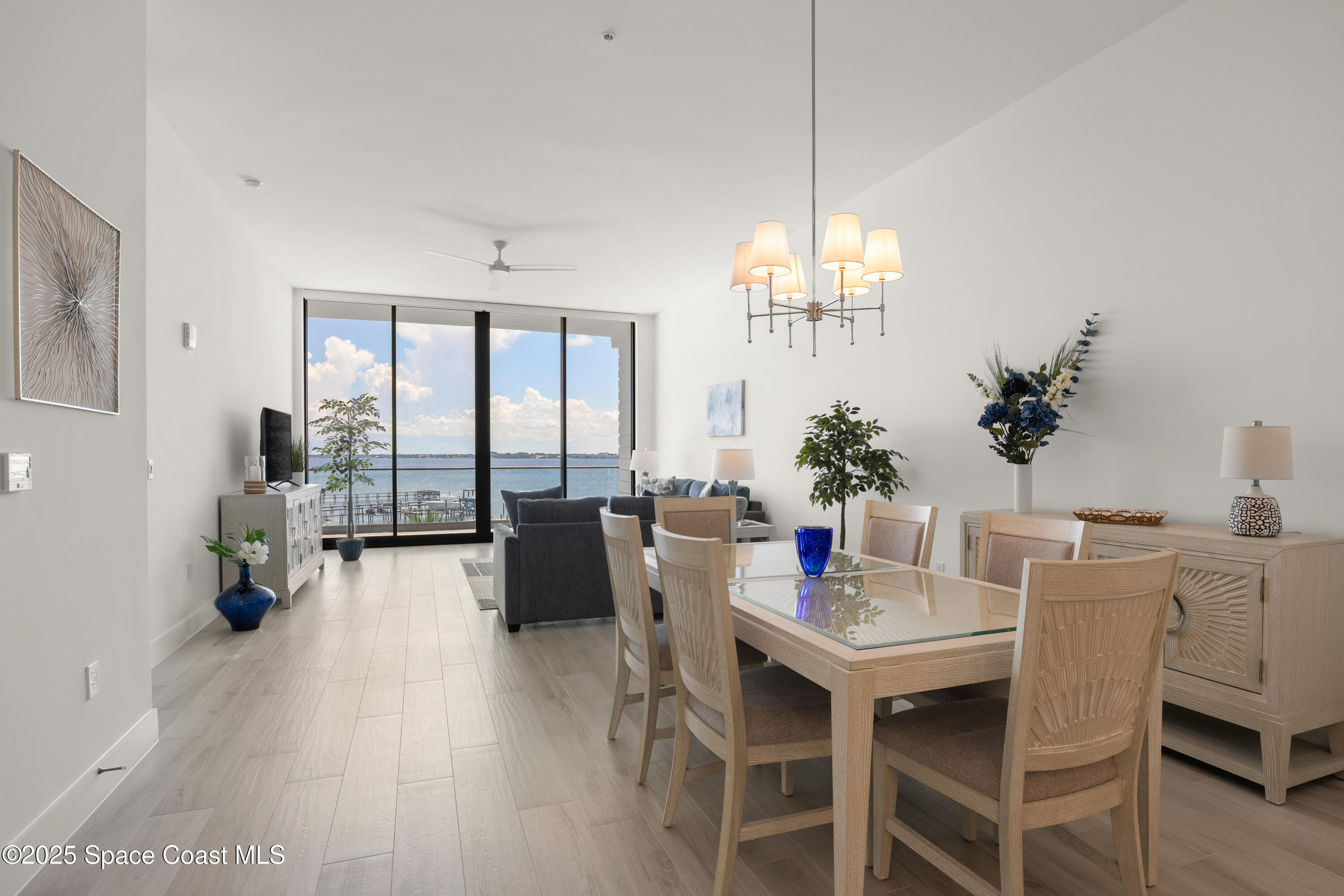 225 Strand Drive, Unit 406 Melbourne Beach, FL 32951 - Photo 14 of 49 a dining room with furniture a chandelier and wooden floor