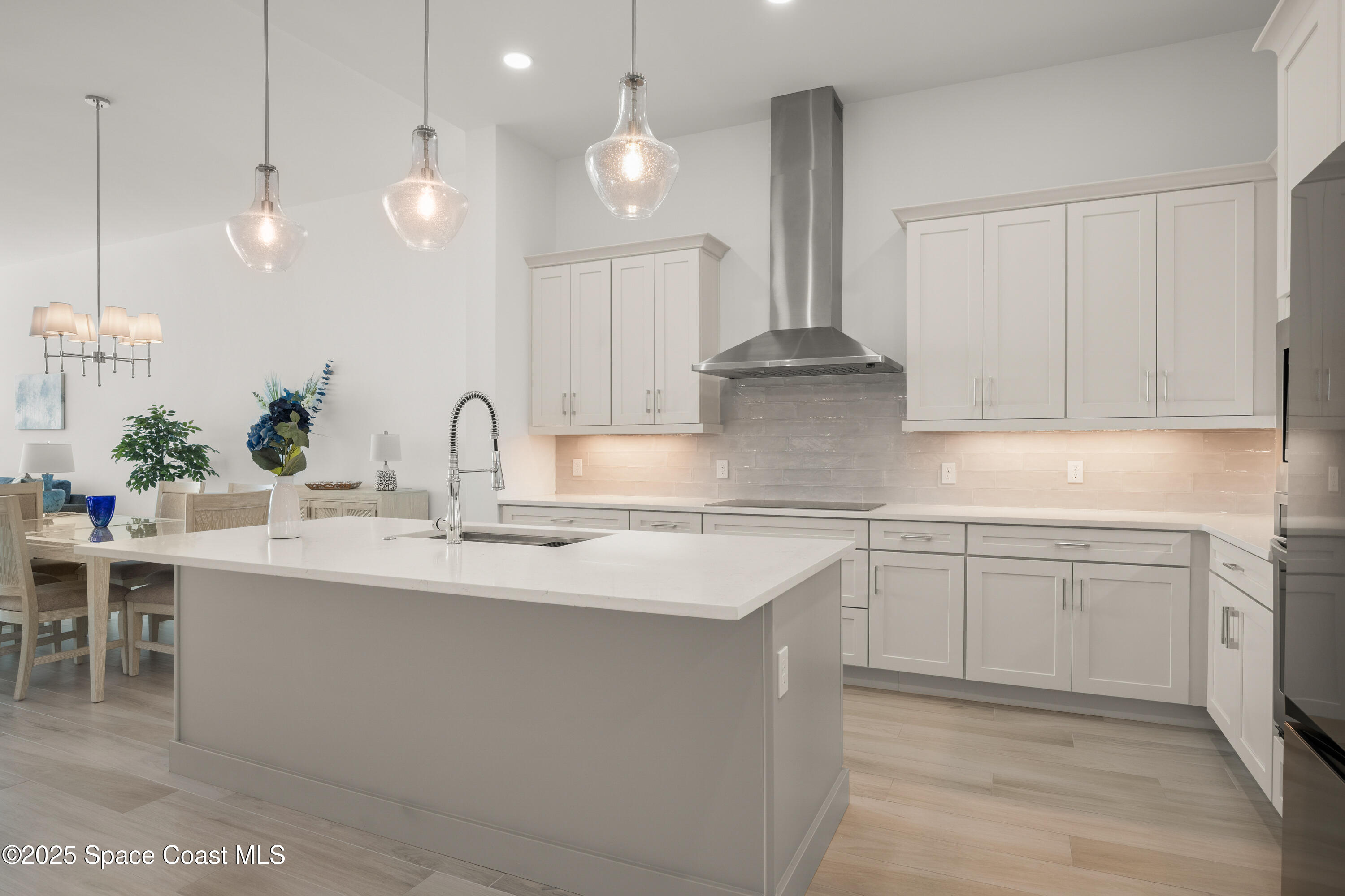 225 Strand Drive, Unit 406 Melbourne Beach, FL 32951 - Photo 17 of 49 a kitchen with kitchen island granite countertop a sink white cabinets and stainless steel appliances