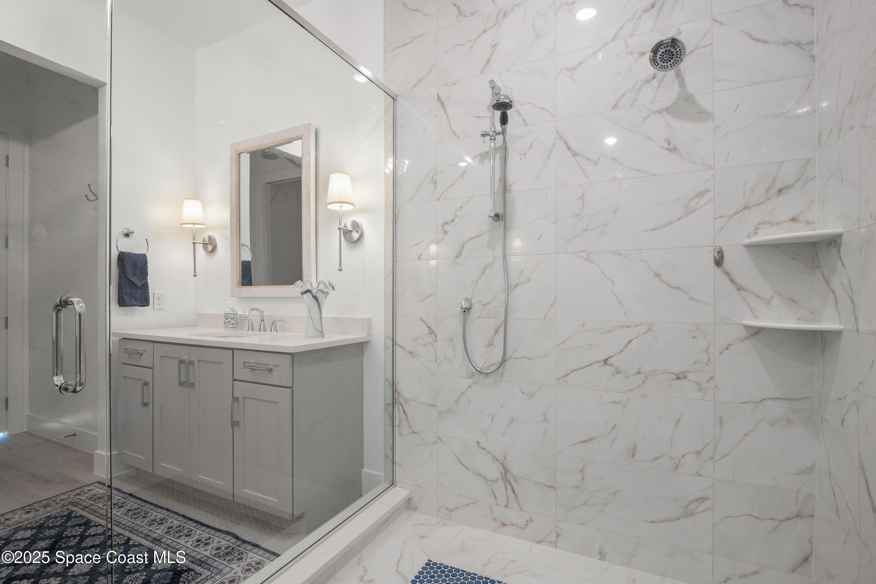 225 Strand Drive, Unit 406 Melbourne Beach, FL 32951 - Photo 25 of 49 a bathroom with a shower sink and mirror