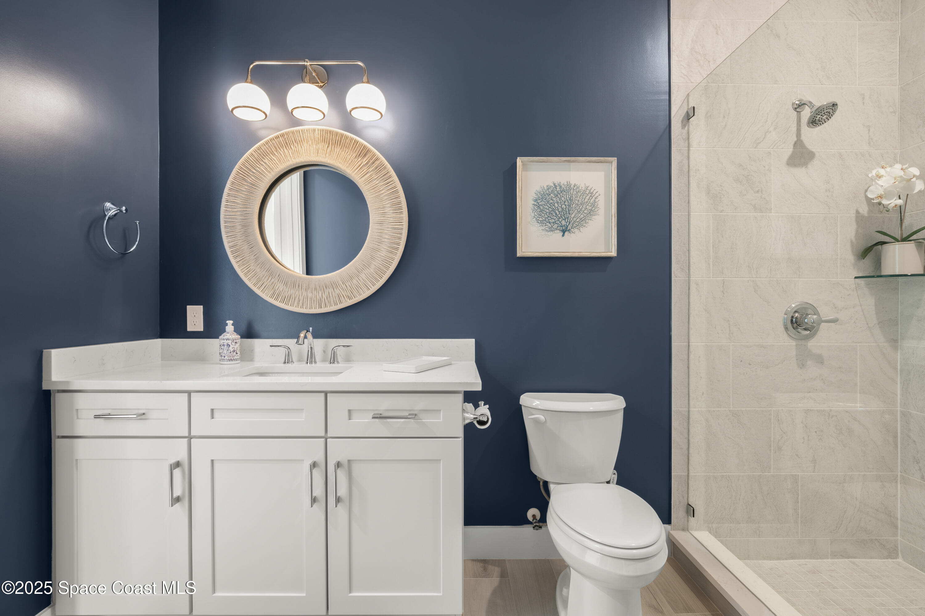 225 Strand Drive, Unit 406 Melbourne Beach, FL 32951 - Photo 35 of 49 a bathroom with a toilet a sink and a mirror