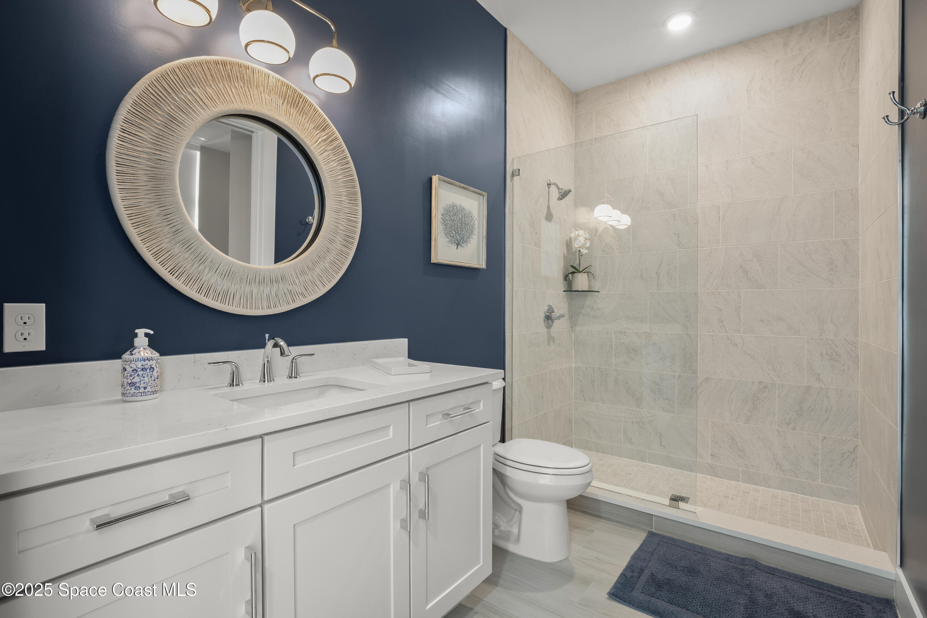 225 Strand Drive, Unit 406 Melbourne Beach, FL 32951 - Photo 36 of 49 a bathroom with a sink a toilet and a mirror