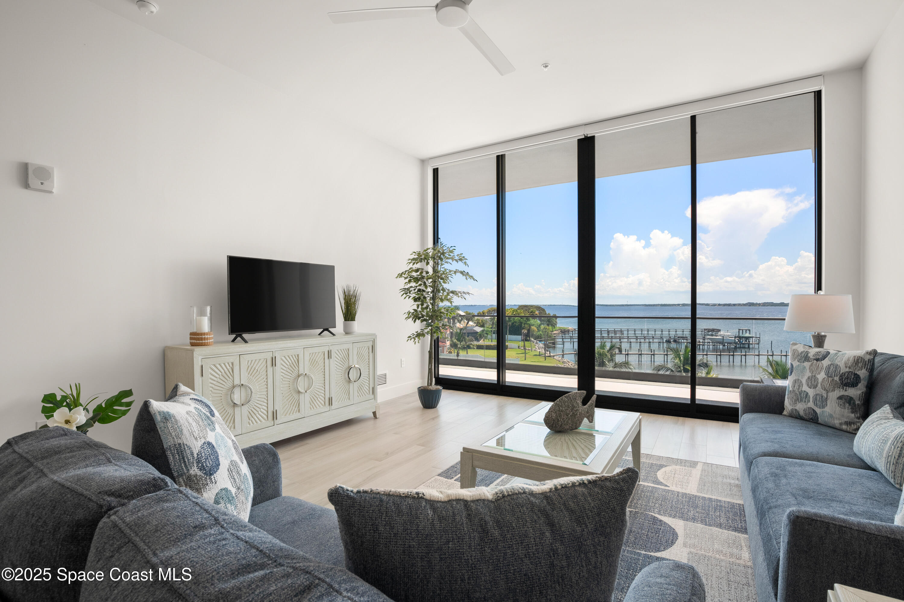 225 Strand Drive, Unit 406 Melbourne Beach, FL 32951 - Photo 10 of 49 a living room with furniture a flat screen tv and a large window