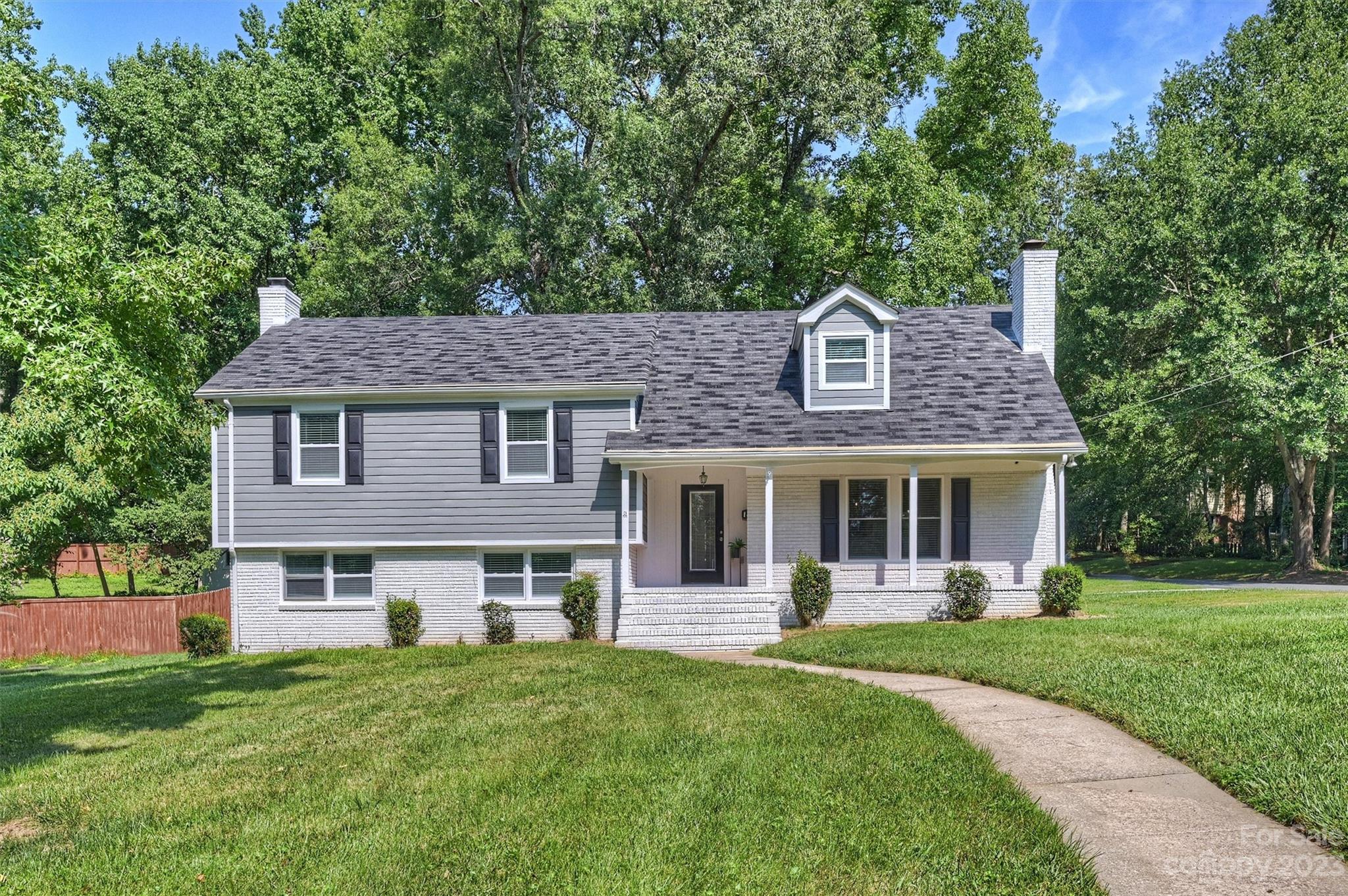 a front view of a house with yard and green space