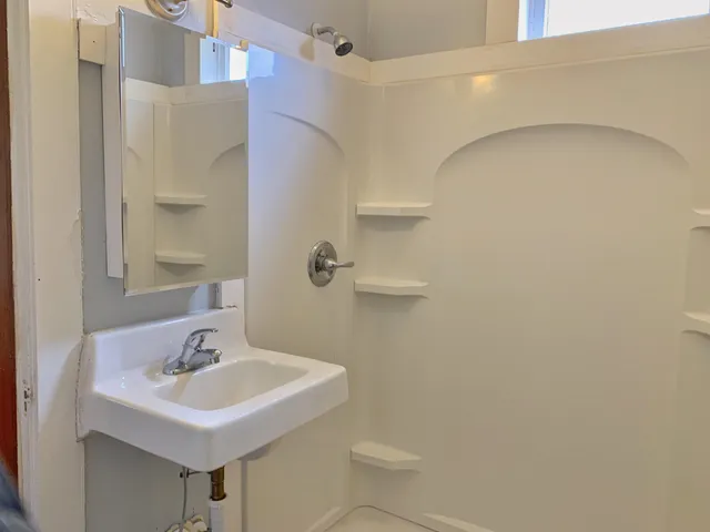 a bathroom with a sink a toilet and shower