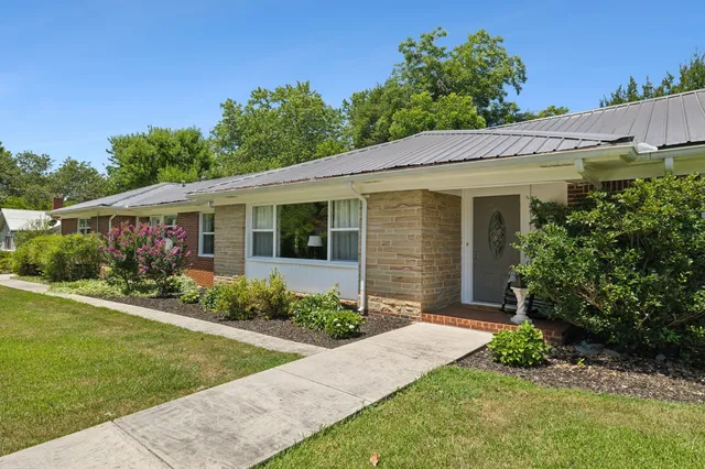 a front view of a house with a yard and potted plants