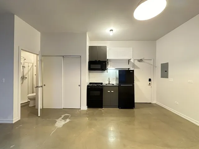 a view of a kitchen with a sink and a refrigerator