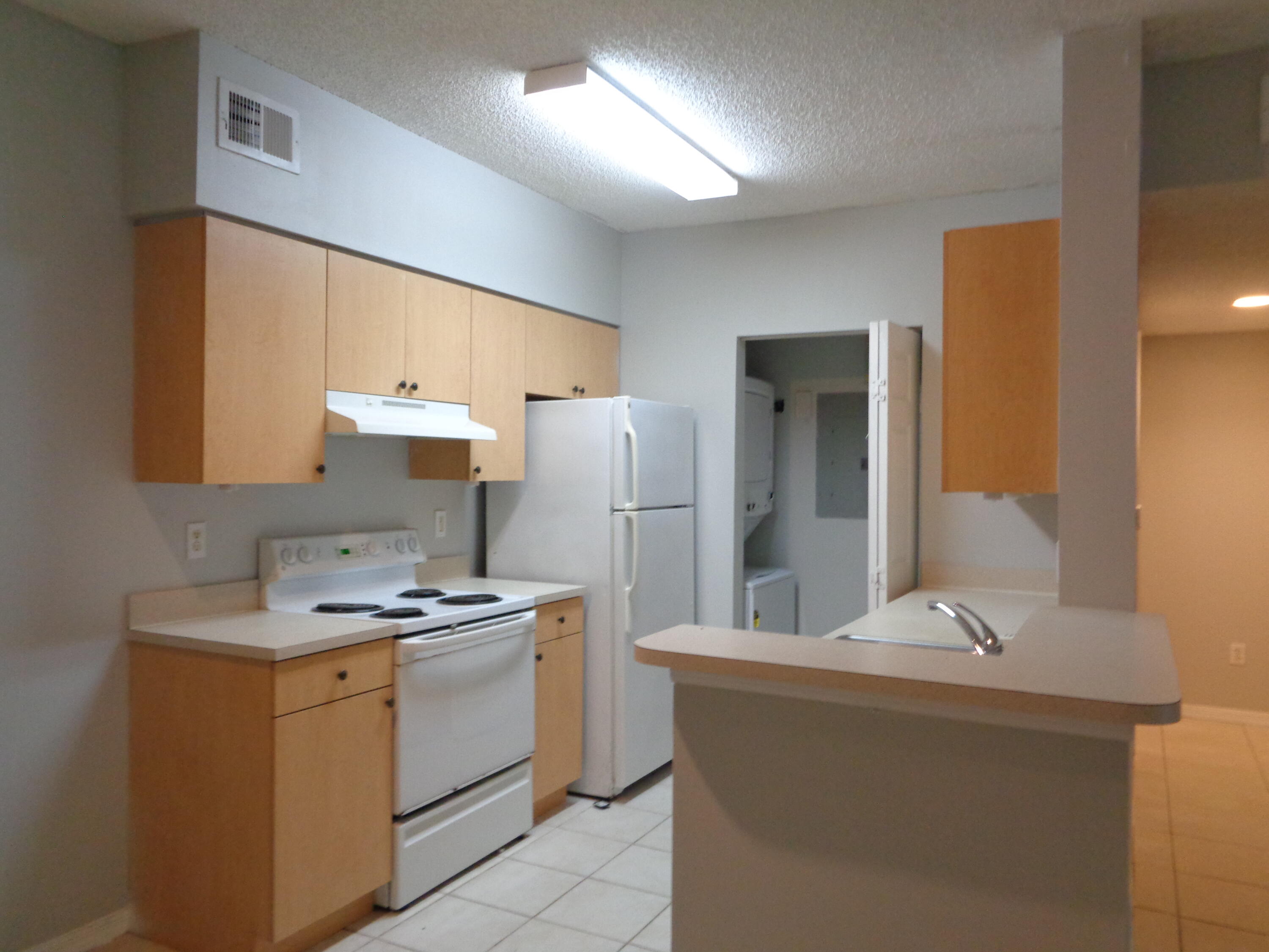 10354 Fox Trail Road South, Unit 1509 Royal Palm Beach, FL 33411 - Photo 7 of 13 a kitchen that has a sink and a stove in it