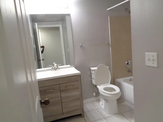 a bathroom with a toilet a sink and mirror