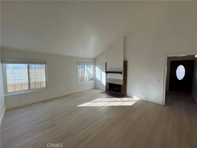 an empty room with windows and fireplace