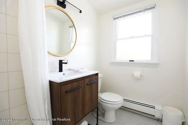 a bathroom with a toilet sink and mirror