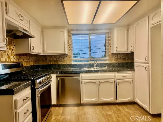 a kitchen with stainless steel appliances granite countertop a stove a sink and a granite counter tops