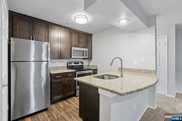 a kitchen with stainless steel appliances granite countertop a sink stove and refrigerator