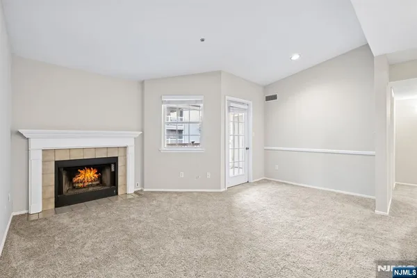 an empty room with windows and fireplace