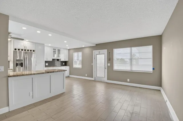 a kitchen with granite countertop white cabinets and white appliances