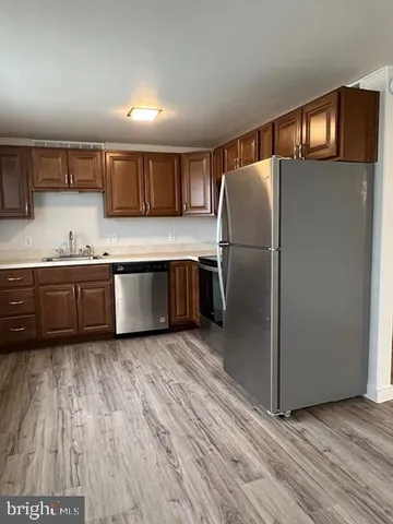 a kitchen with stainless steel appliances granite countertop a refrigerator and a sink
