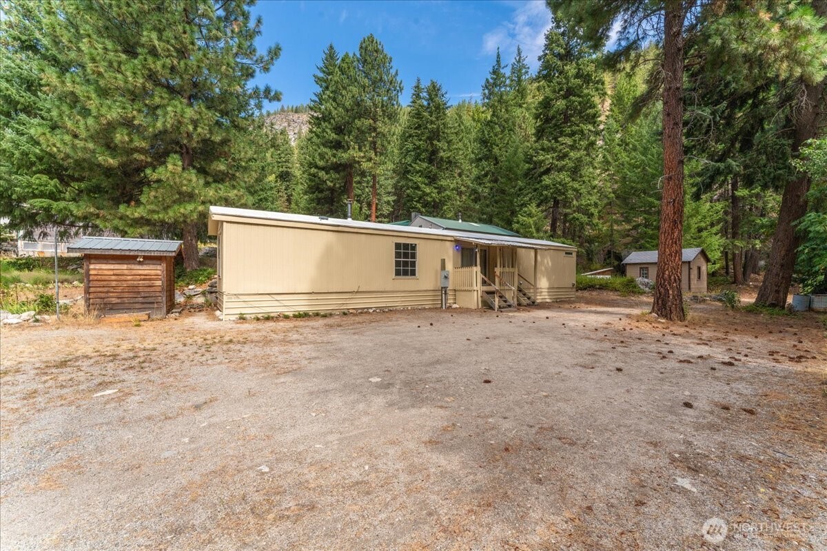 a view of a house with backyard and trees