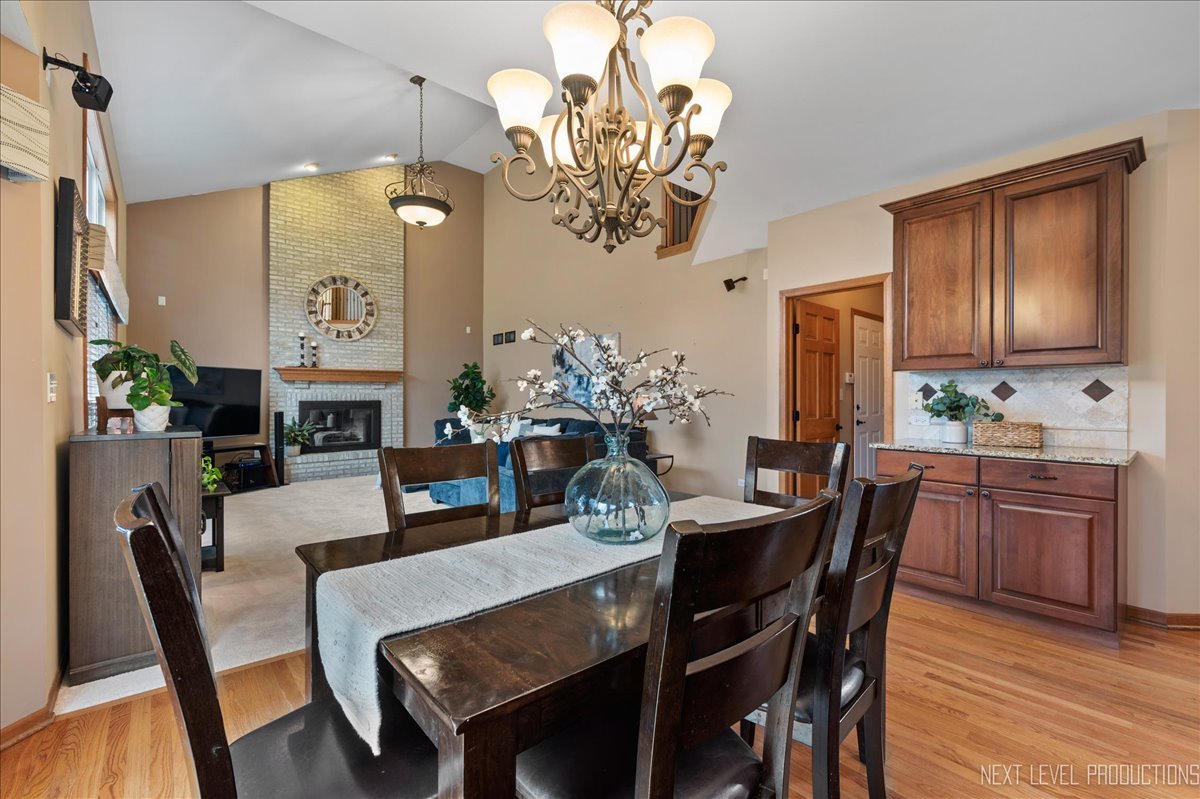 2620 Sweetbroom Road Naperville, IL 60564 - Photo 12 of 30 a view of a dining room with furniture a chandelier and wooden floor