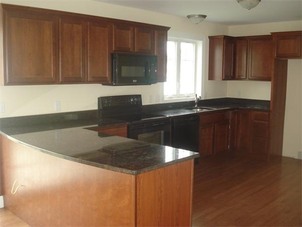 311 Arnold Springfield, MA 01119 - Photo 3 of 22 a kitchen with granite countertop a sink a stove a microwave and wooden cabinets