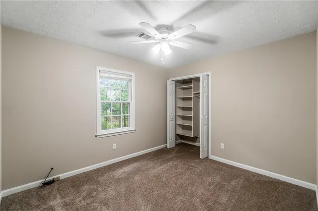 an empty room with windows and closet