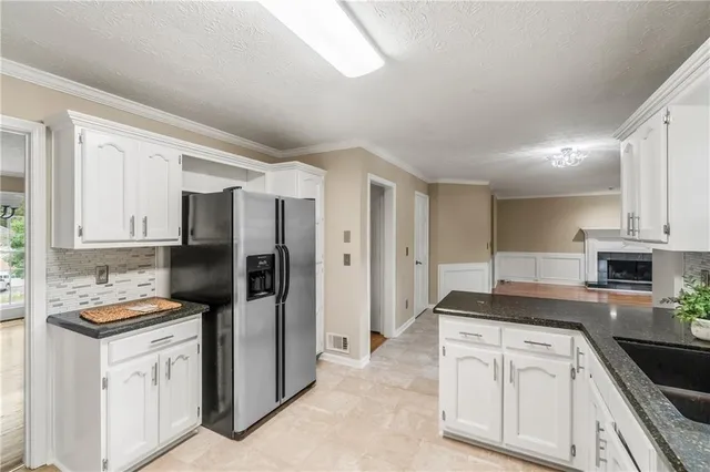 a kitchen with refrigerator a stove and cabinets