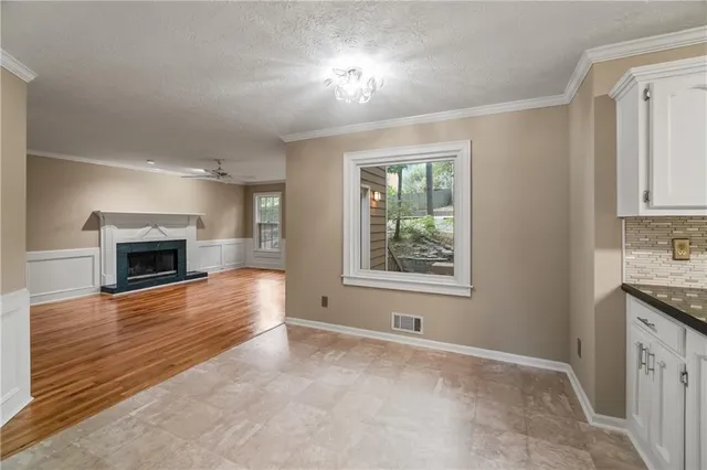an empty room with windows and fireplace
