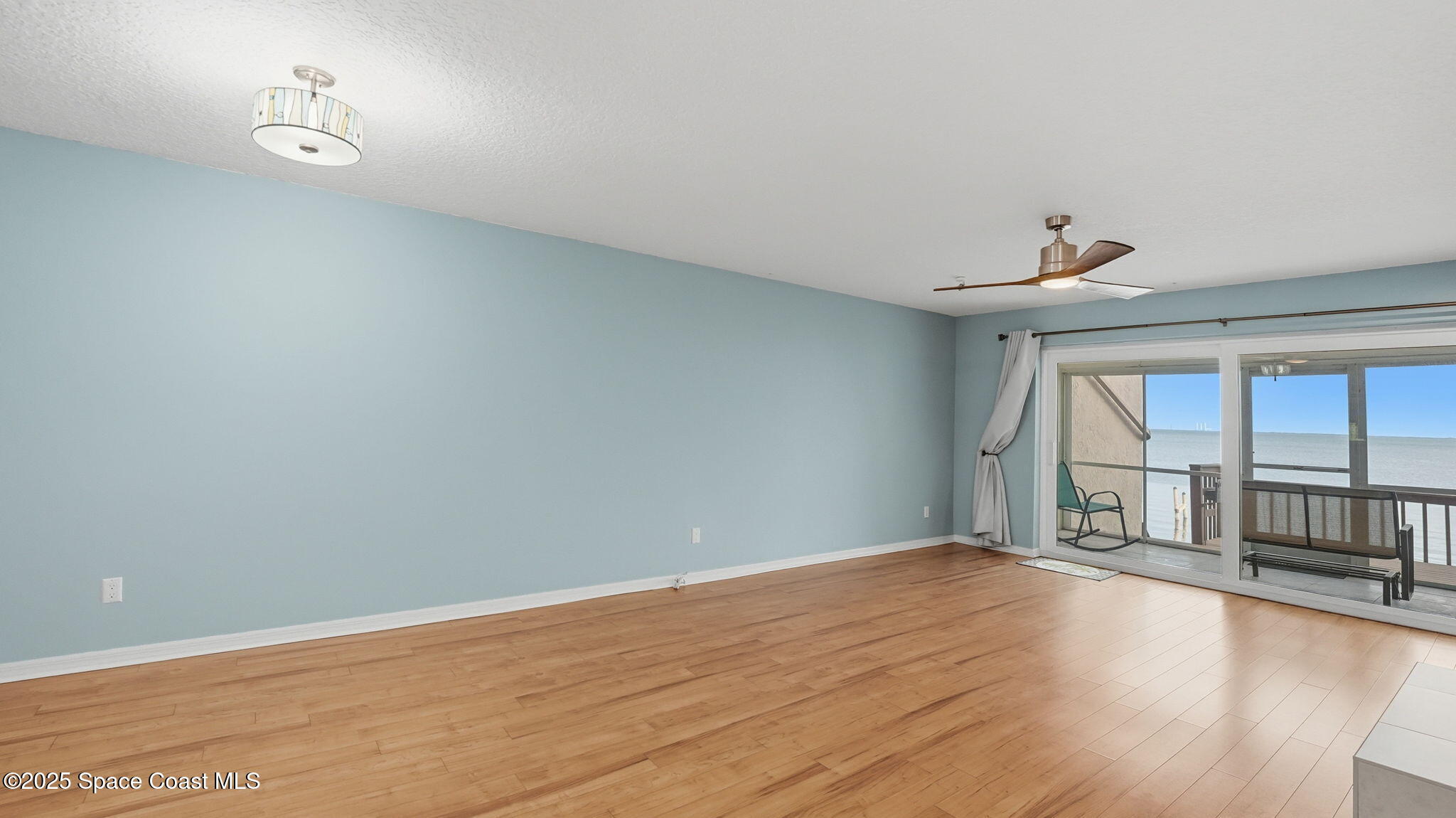 5087 Riveredge Drive, Unit 2 Titusville, FL 32780 - Photo 11 of 62 wooden floor in an empty room with a window
